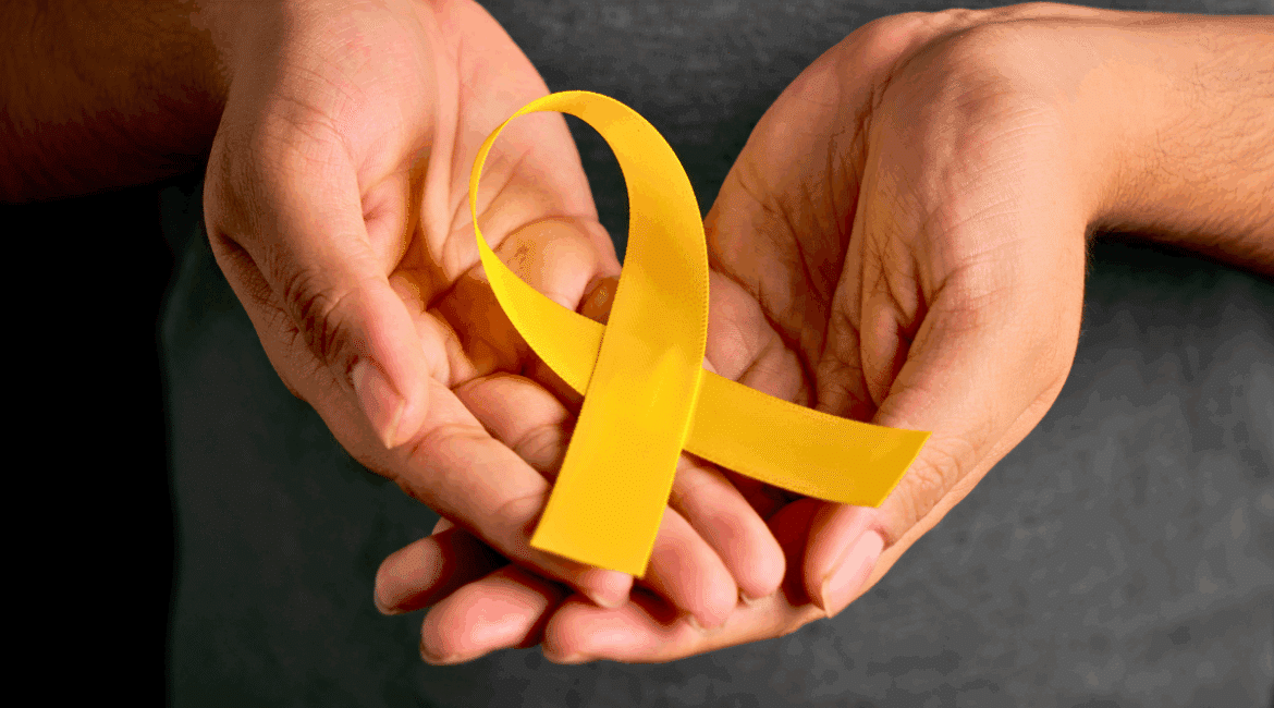 A picture of hands holding a yellow ribbon.